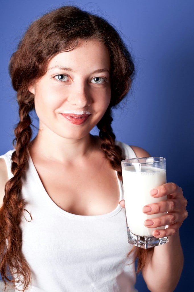 Young woman smiling with a glass of milk